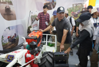 Wabup Bolmong Dony Lumenta mengamati mesin traktor pada salah satu stan pameran teknologi pertanian di PENAS XVII Gorontalo.